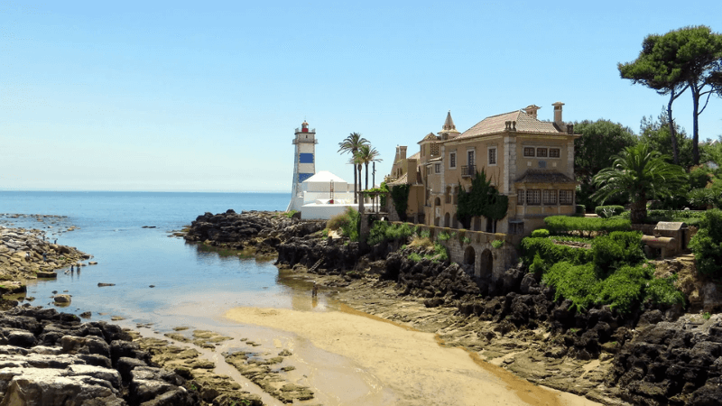 Small charming Praia de Santa Marta next to Cascais marina with calm waters and sunny beachgoers